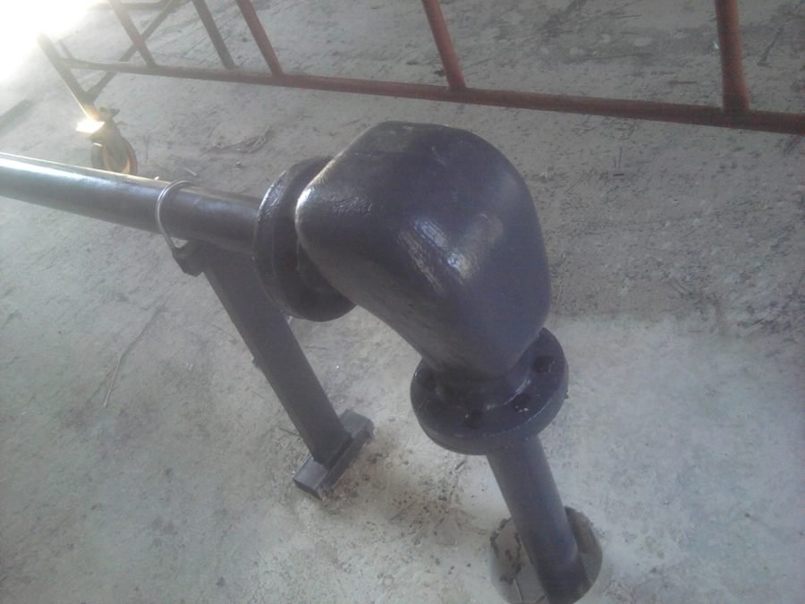 Installed conveying elbow and adjacent process pipework